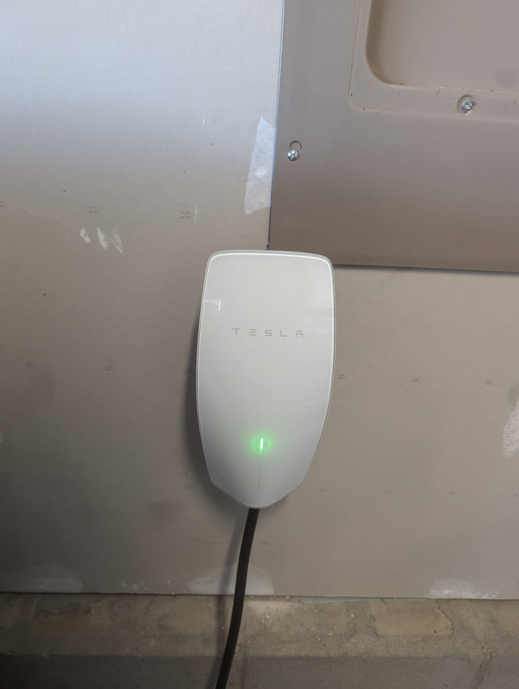 Tesla wall connector mounted in a garage